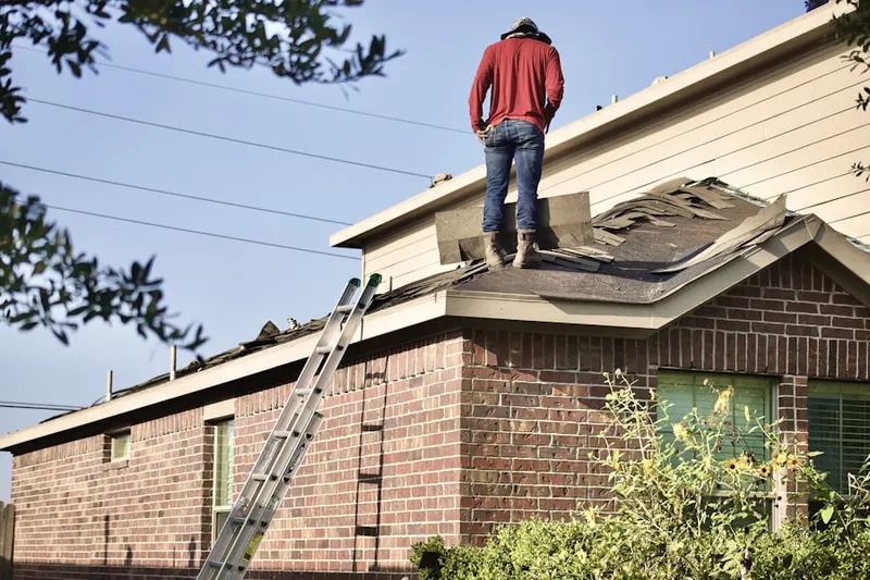 Professional roofer working on a residential roof in Boon